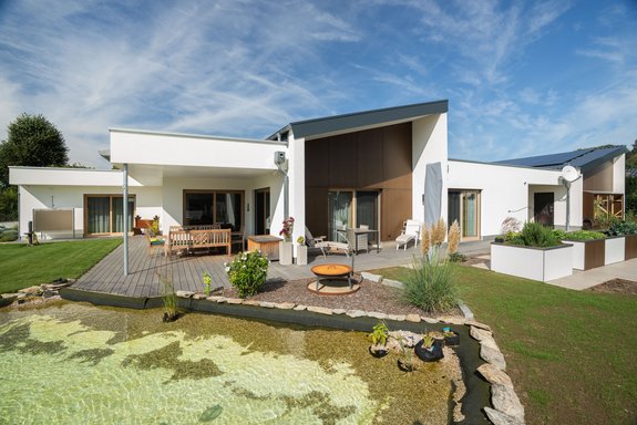 Bungalow mit Putzfassade, Walmdach und Naturpool