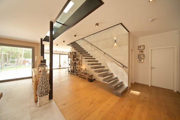 Innenaufnahme Betonwand mit freitragender Treppe und Glaselementen in der Decke