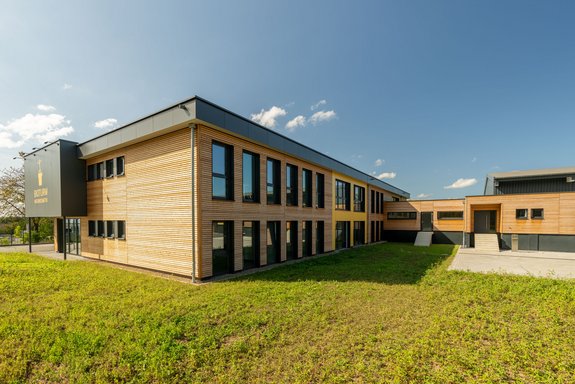 Bürogebäude mit Lagerhalle mit Lärche Trendliner Holzschalung und Fundermax Fassadenplatten