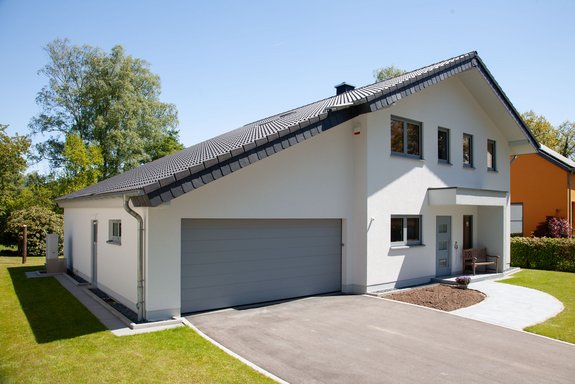 Weißes Holzhaus mit Satteldach und Doppelgarage