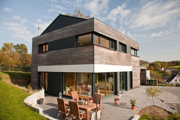 Einfamilienhaus mit Holzschalung aus Thermoesche und Fundermax Fassadenplatten