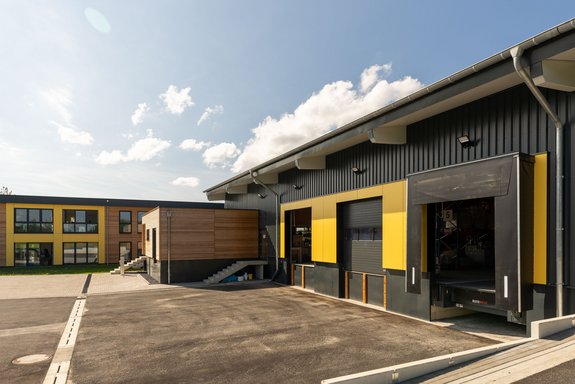 Bürogebäude mit Lagerhalle mit Lärche Trendliner Holzschalung und Fundermax Fassadenplatten