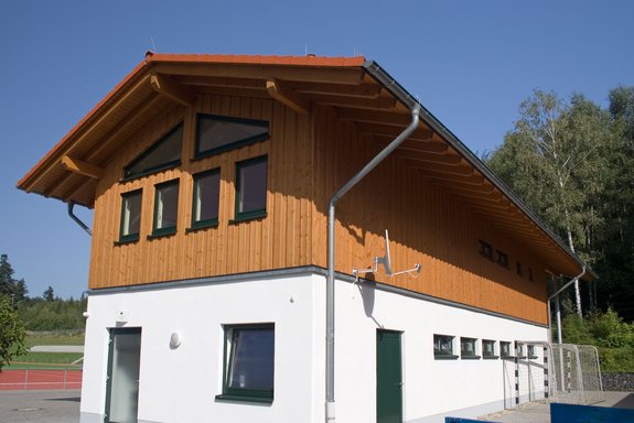 Sportlerheim mit senkrechter Holzverschalung