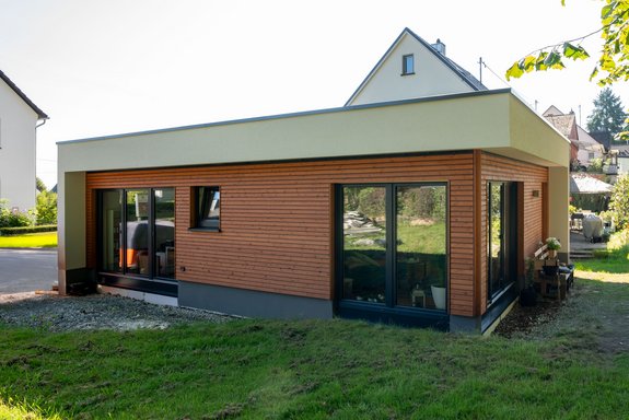 Anbau mit Flachdach und Holzfassade
