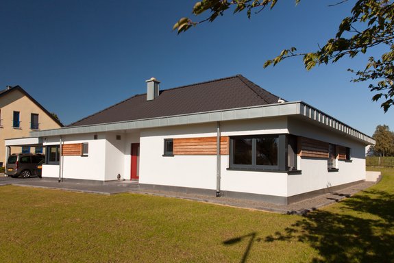 Bungalow mit und zurückgesetztem Dach und abgesetzten Fassadenflächen in  Keil-Stülpp Schalung