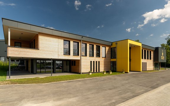 Bürogebäude mit Lagerhalle mit Lärche Trendliner Holzschalung und Fundermax Fassadenplatten