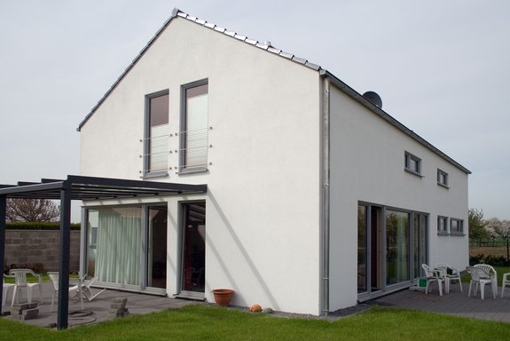 Satteldachhaus mit Putzfassade und filigraner Pergola
