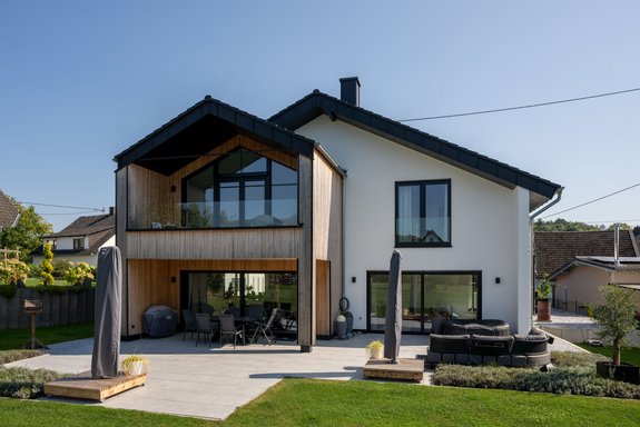 Moderne Holz-Putz-Fassade mit kontrastreichem Satteldach und Flachdach-Garage